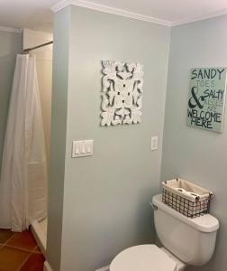 泰比岛Pearls Pad - Beautiful 1 bedroom apartment- 1 block to beach的一间带卫生间的浴室和墙上的标志