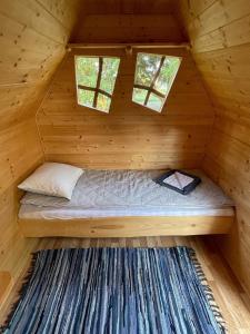 VäratiKünkaotsa的小木屋内的一张床位,设有两个窗户