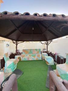 沙迦Holiday Home Rent villa的一间设有椅子和一张绿草桌子的房间
