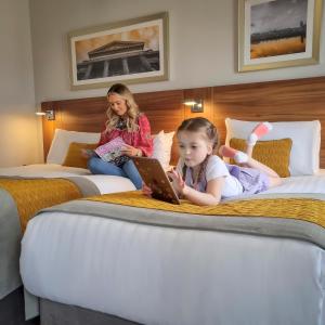 伦敦德里德里玛尔顿酒店的坐在两张床上的小女孩,手提电脑