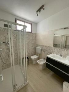 米兰马瑞提那Appartamento LA ROTONDA的带淋浴、卫生间和盥洗盆的浴室