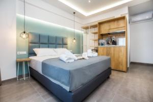 利迈纳里亚New Azzurro Deluxe的一间卧室配有一张大床和两条毛巾