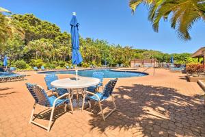 蒙内罗亚Peaceful Condo with Amenities Steps to Beach!的游泳池前配有桌椅和遮阳伞