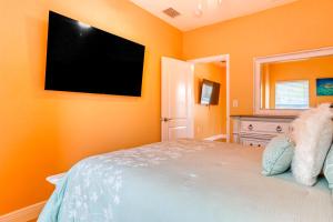 克利尔沃特East Shore Paradise #448的一间卧室设有带平面电视的橙色墙壁