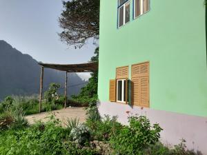 CaculiPousada Rural Simpatia的绿色和白色的建筑,设有窗户