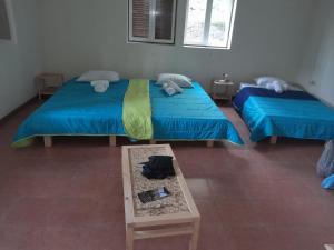 CaculiPousada Rural Simpatia的带桌子的客房内的两张单人床