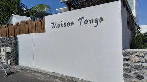 圣皮埃尔Maison TONGA piscine - jacuzzi confort的白色的墙,标有飞行任务的标志