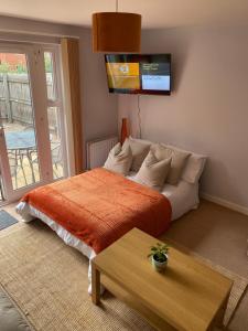 考文垂Coventry City Centre townhouse with private parking的一间卧室配有一张带橙色毯子的床