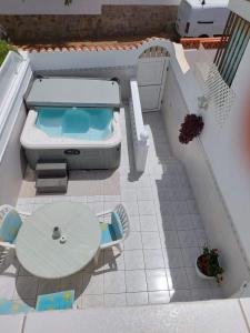 德尔锡伦西奥海岸Jacuzzi House Sunflower的一个带桌子和浴缸的游泳池模型