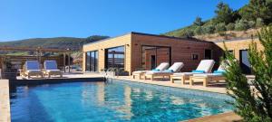阿伦克尔Sóis Montejunto Eco Lodge的一座带躺椅的游泳池的房子