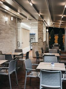 地拉那Amansar Boutique Hotel的一间在房间内配有桌椅的餐厅