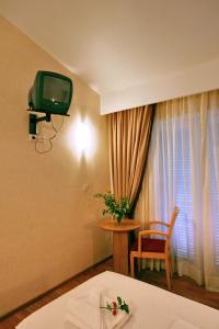 普洛马里翁沙湾酒店的配有电视、桌子和窗户的酒店客房