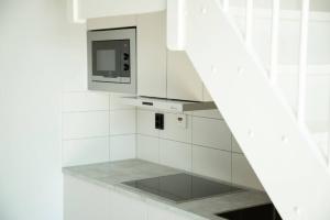 利丁厄SK67 Stylish and Full Equipped loft with free parking的白色的厨房配有微波炉和炉灶。