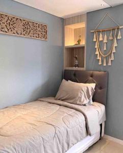 万隆Daymentroom R32 Apartemen 2 BR Pasteur Bandung的卧室内的一张床铺,卧室内有蓝色的墙壁