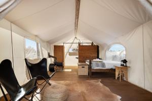 瓦莱Under Canvas Grand Canyon的一个带一张床和椅子的帐篷