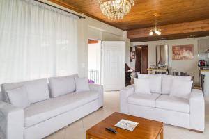 FayiásSohoro house的客厅配有2张白色沙发和1张桌子