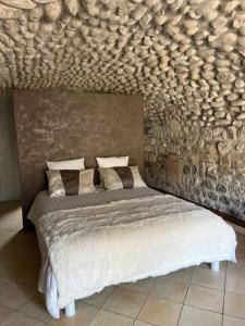 欧布纳GITE DE LA CAPPELLA - CHAMBRE D'HÔTES A VOLTA的一间卧室配有一张石墙床