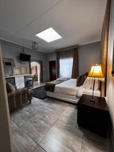 约翰内斯堡Silken Trap Guest House NO LOADSHEDDING的一间卧室配有床、沙发和灯