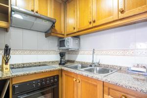 贝尼多姆Gemelos 22 Resort Apartment 2-15-B Levante Beach的厨房配有木制橱柜、水槽和微波炉