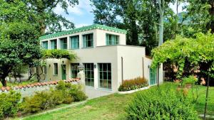 科莫The Greenhouse Luxury Villa on Lake Como的白色的房屋,设有绿色的屋顶
