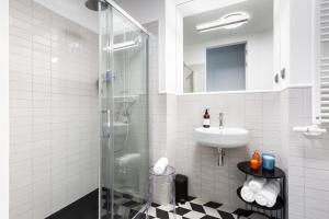 克拉科夫H11 Aparthotel的一间带玻璃淋浴和水槽的浴室
