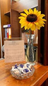 伦敦布鲁姆斯伯里格雷西姆酒店的桌子上的一个花瓶,上面放着向日葵