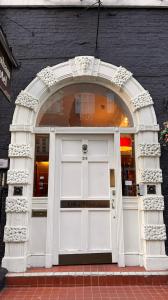 伦敦布鲁姆斯伯里格雷西姆酒店的通往商店的拱形入口,有白色门