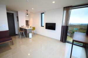 济州市济州岛维斯塔度假村的客厅设有大窗户和电视。