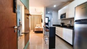 里贝朗普雷托Nova aliança 56 -wifi -estacionamento -3 hóspedes的厨房配有白色橱柜和台面