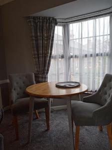 BemptonCherry Tree Cottage的客厅配有桌子、两把椅子和窗户