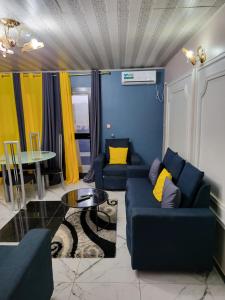 雅温得Lux Résidence的客厅配有2张蓝色的沙发和1张桌子