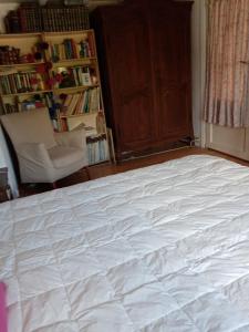 KapellenEmcée B&B的卧室配有一张白色大床和一把椅子