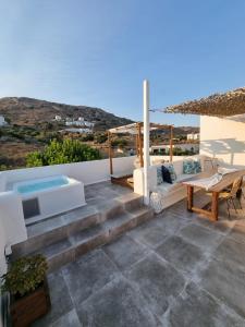 纳克索乔拉Ninemia Naxos Suites的一个带沙发和桌子的庭院和一个游泳池