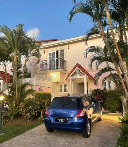 圣詹姆斯Nanpa, Luxury Family Three Bed Villa, St James West coast, Private pool的停在房子前面的蓝色汽车