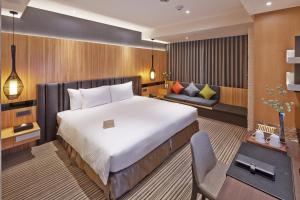 台中市丰邑逢甲商旅的一间卧室配有一张大床和一张沙发