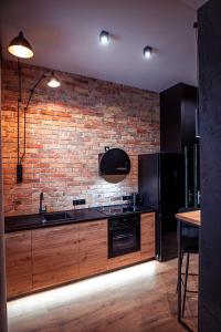 克维曾Apartments Kwidzyn的厨房配有木制橱柜和砖墙