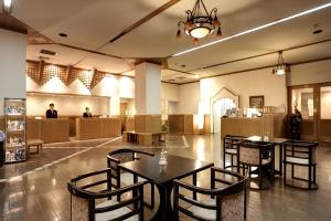 别府新鹤田酒店的大堂设有2张桌子和椅子,酒店还设有一间自助餐厅。