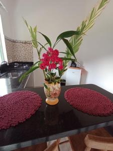 帕拉蒂Chalés Vale dos Pássaros的一张桌子,上面有红花花瓶