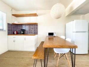 好莱坞The Delmar的厨房配有木桌和白色冰箱。