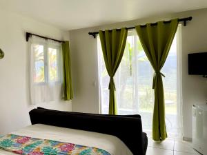 Ujarrás瑞尼科特韦德酒店的一间卧室配有绿色窗帘、一张床和窗户