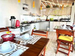 圣米格尔-杜戈斯托苏AYRE GOSTOSO POUSADA的带木桌和椅子的厨房以及带柜台的厨房。