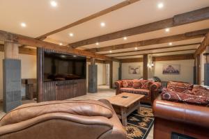 黑利Bear Lodge with private Pool, Hottub, and Sauna!的客厅配有皮革家具和平面电视