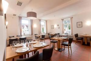 施派尔哈蒙德宾馆的餐厅设有木桌、椅子和窗户。