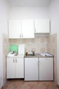 波拉斯Apartments by the sea Polace, Mljet - 613的厨房配有白色橱柜和水槽