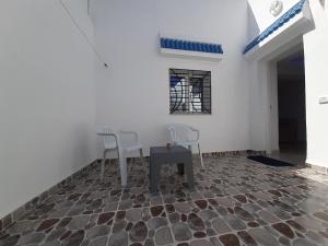 哈马马特Dar salah的一间石地板上的房间,配有两把椅子和一张桌子