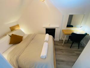 伦敦Cosy flat in London的一间卧室配有一张带书桌和一张书桌的床。