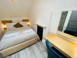 伦敦Cosy flat in London的一间卧室配有一张床、一张书桌和一个窗户。