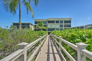 萨尼贝尔Luxury Sanibel Condo with Ocean View Steps to Beach的通往棕榈树建筑的木板路