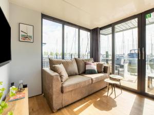 福伦丹Comfortable houseboat in Marina Volendam的带沙发和大窗户的客厅