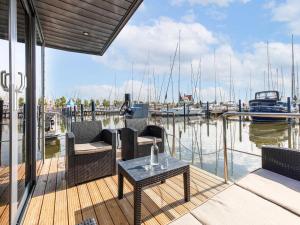 福伦丹Comfortable houseboat in Marina Volendam的码头上带椅子和桌子的门廊